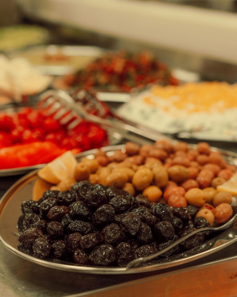 A vibrant display of assorted olives and appetizers on a buffet spread. Perfect for Mediterranean cuisine visuals.