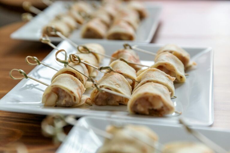 Deliciously plated rolled appetizers on skewers, perfect for events.